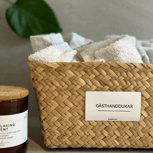 Etikett för gästhanddukar på korg i badrum